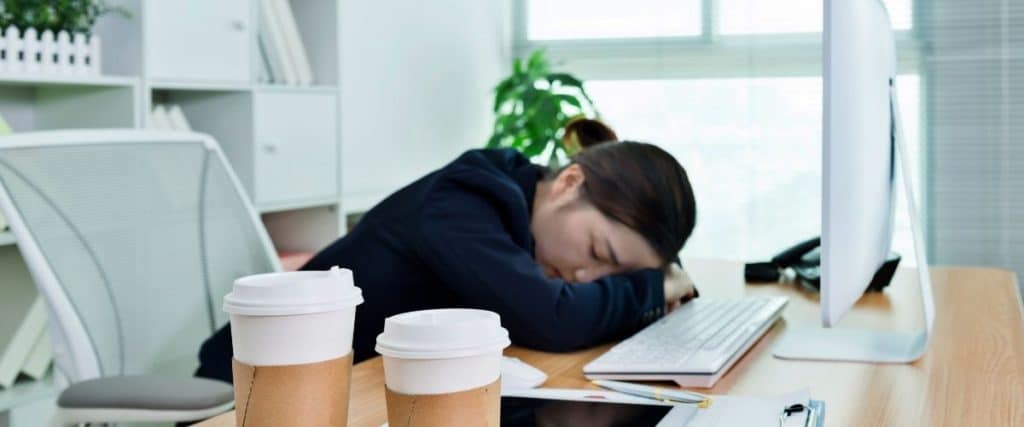 Young lawyer exhausted at desk from long hours