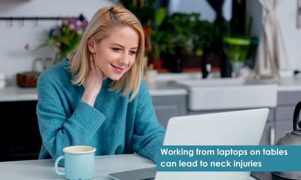 Women holding neck while working from home on laptop