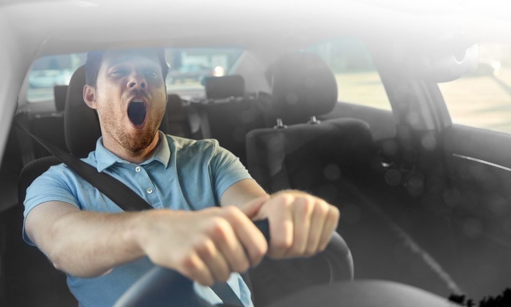 Photo of man yawning as sleepy while driving