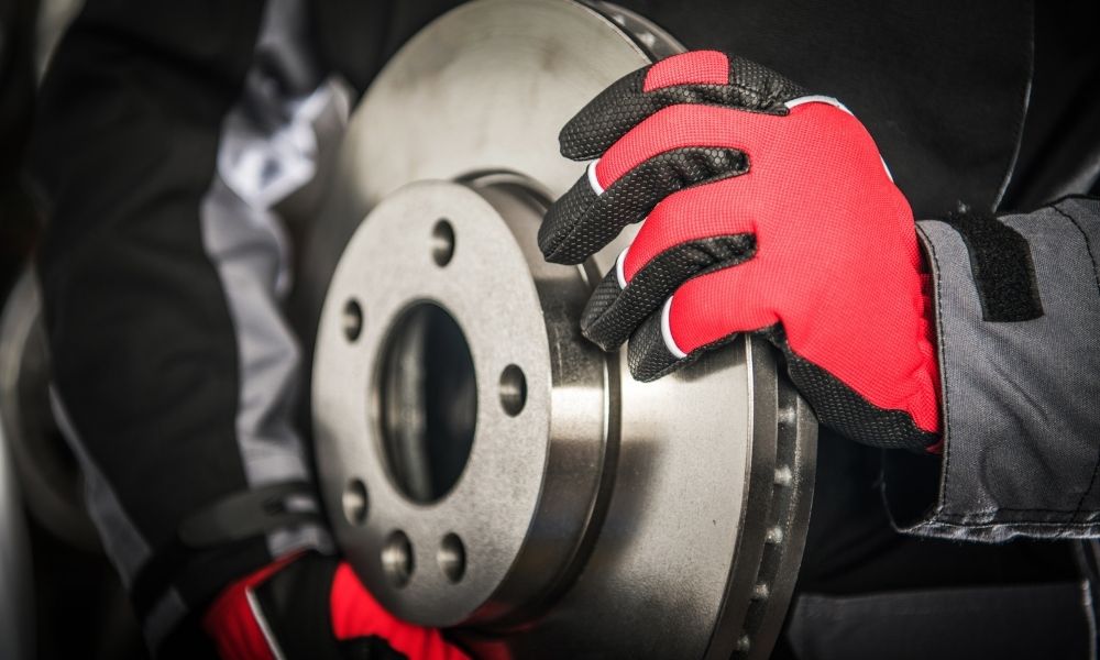 Disc brakes being held by red and black racing gloves