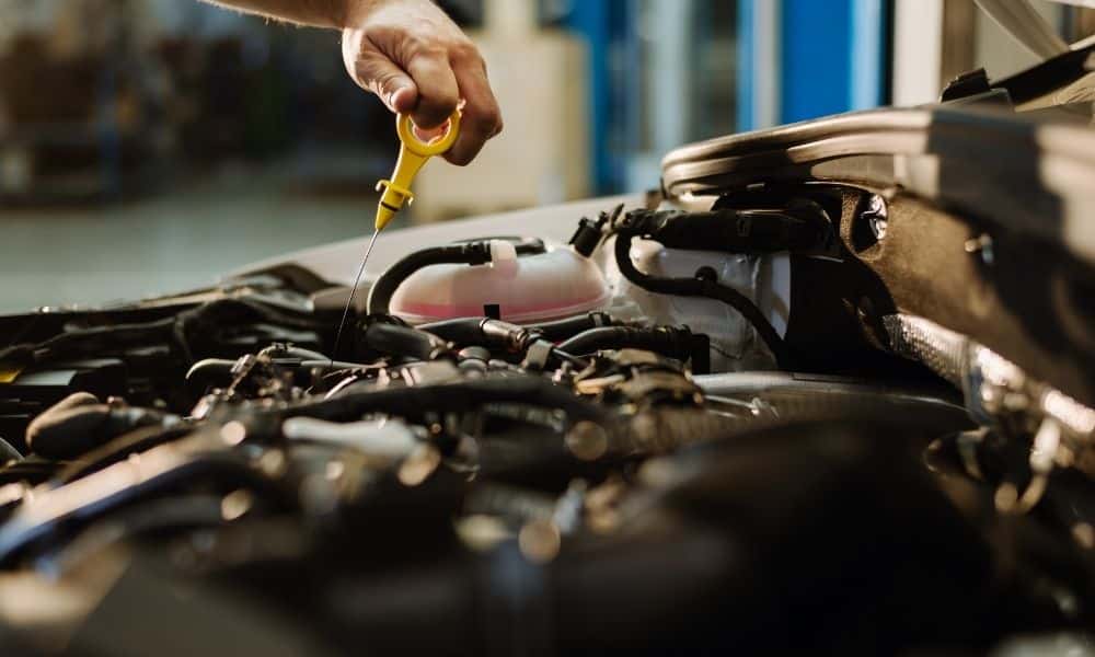 Engine oil levels being checked by a dip stick