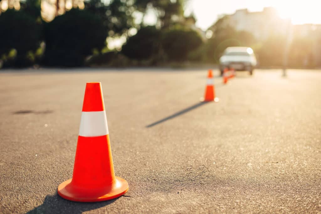 Cones on tarmac with car in the background of defensive driving course